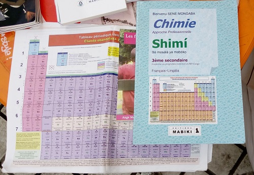 Le tableau de Mendeleïev et un manuel de scolaire de chimie en lingala publié aux Editions Mabiki (DR)